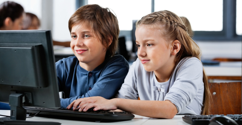 Boy And Girl Using Desktop Pc In School Computer Lab